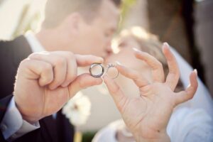 bride groom holding wedding ring-kissing